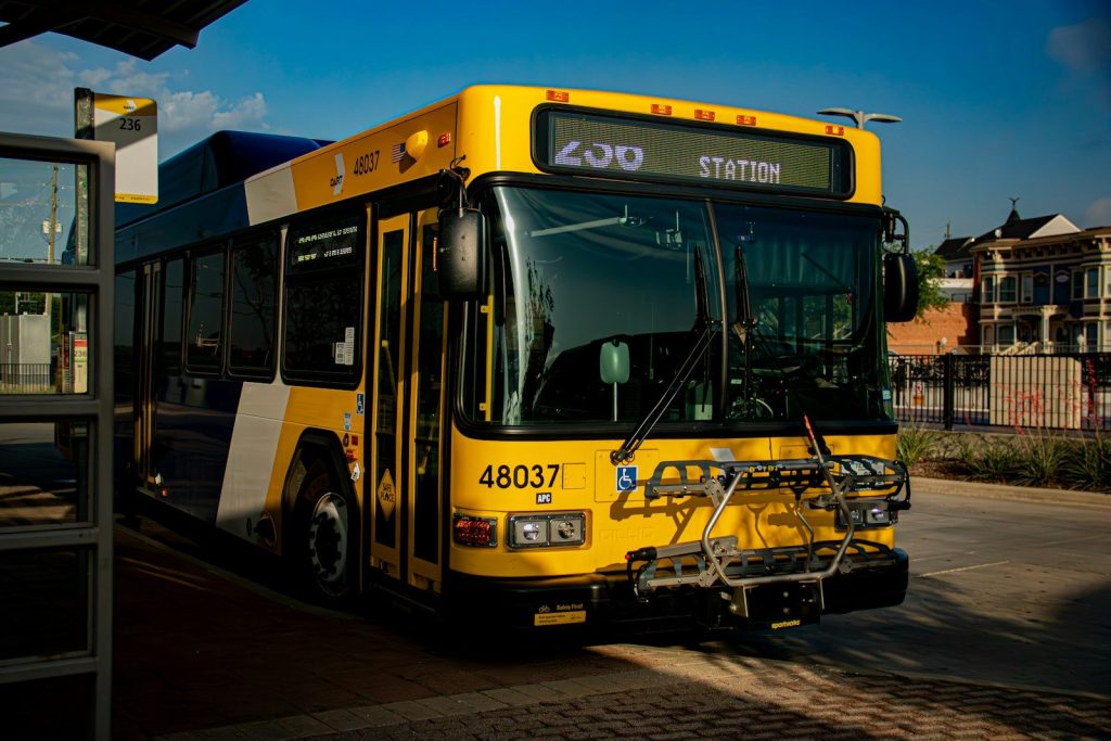 A yellow public transit bus parked at a station.