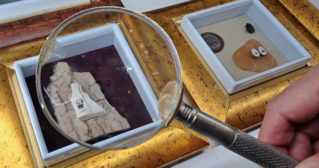 a hand holding a magnifying glass over a picture