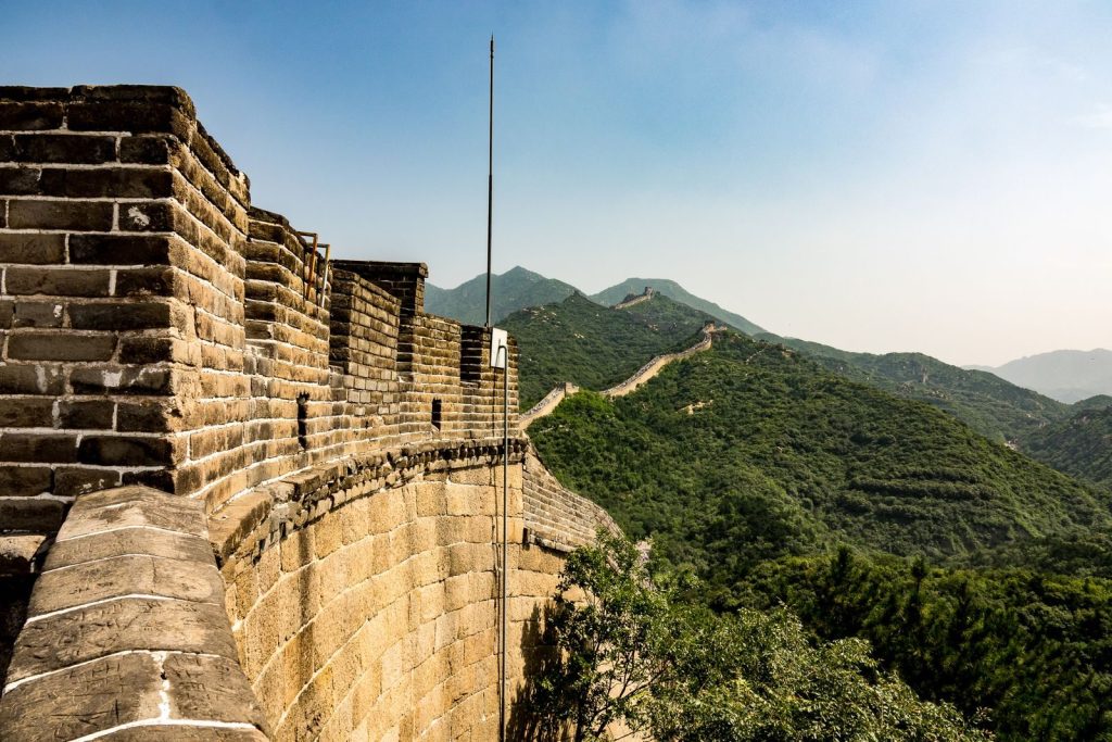 Stunning view of the Great Wall winding through lush hills under a clear sky.