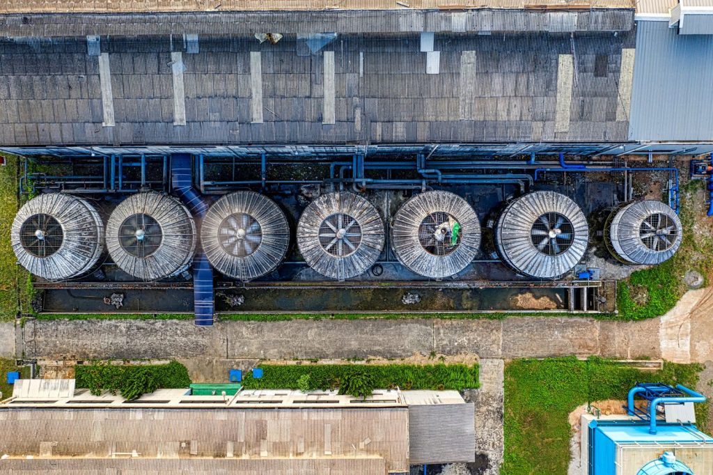 Drone view of industrial terrain with treatment plants located in suburban area in sunlight