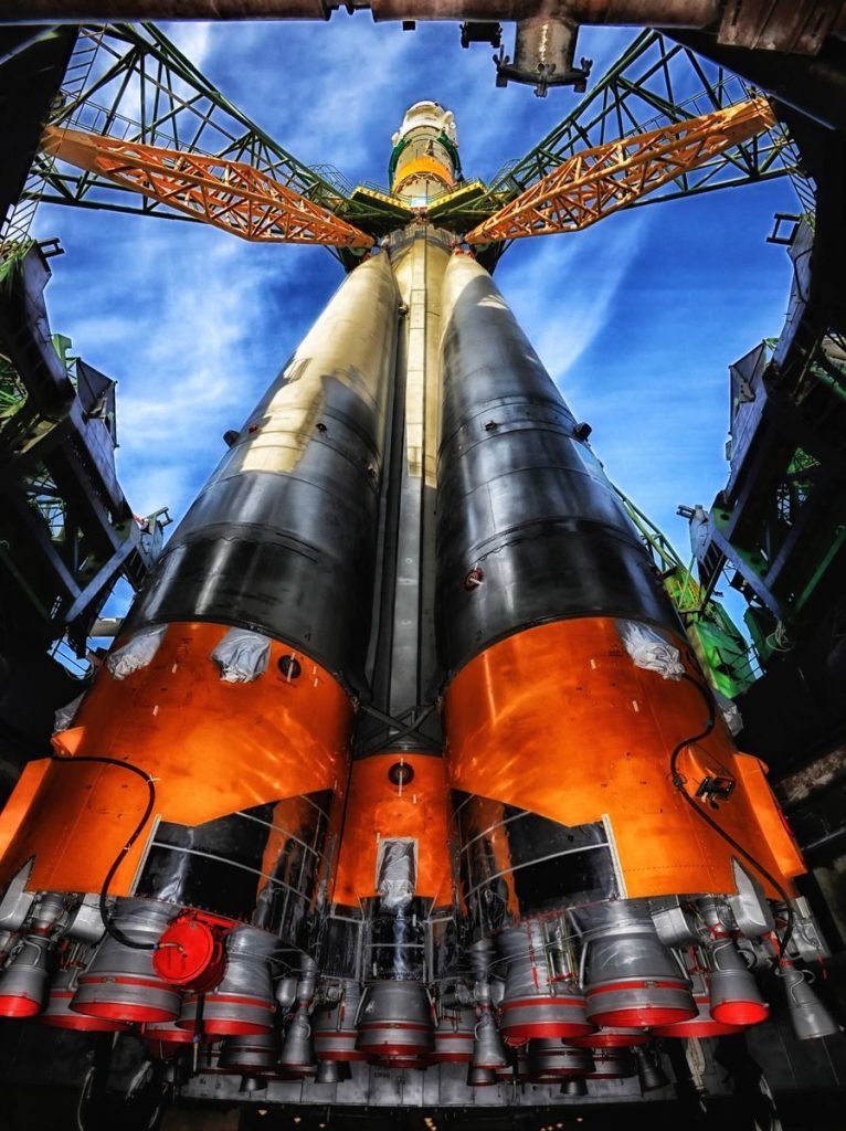 A vibrant low angle view of a rocket on a launch pad against a clear blue sky.