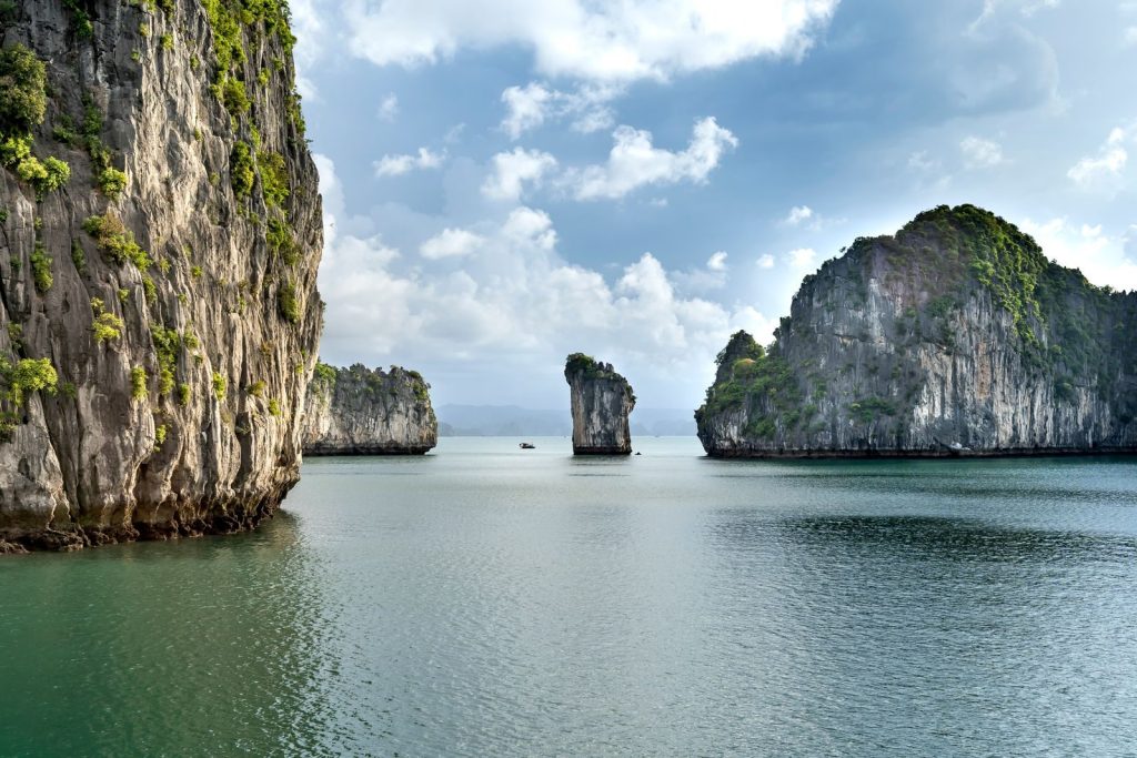 Serene view of towering limestone cliffs and tranquil waters on a sunny day.