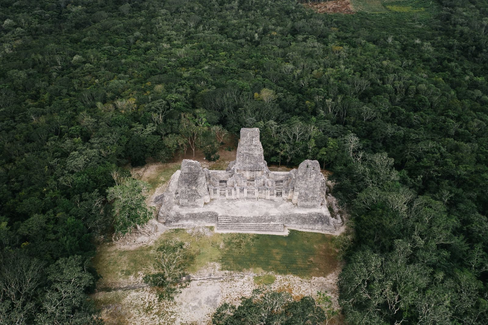 An aerial view showcasing ancient Mayan ruins surrounded by lush jungle.