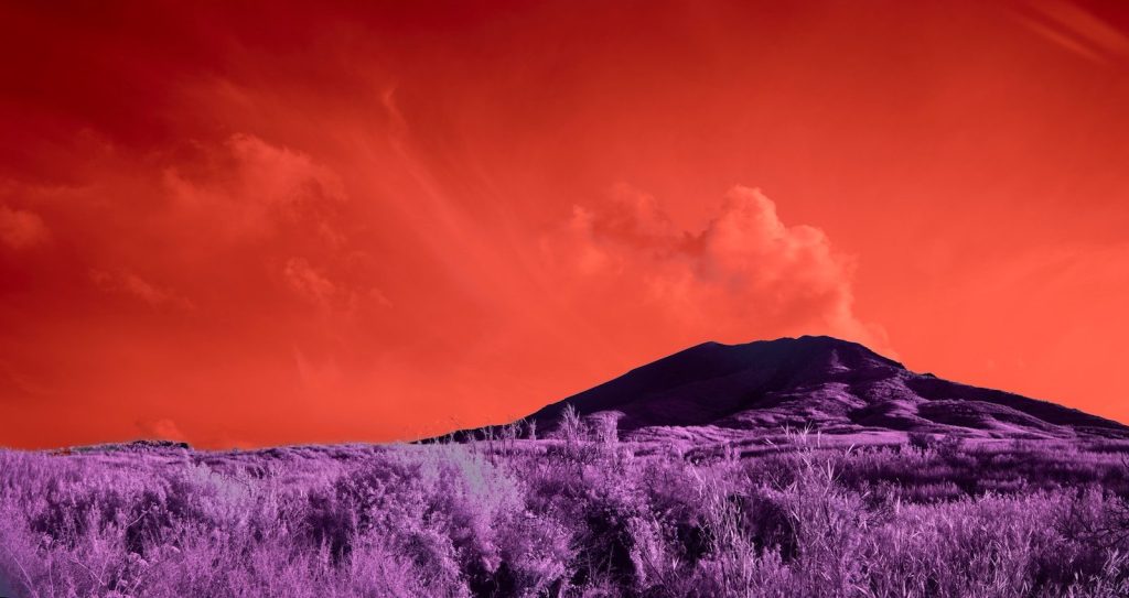 A lone mountain under a fiery orange sky.