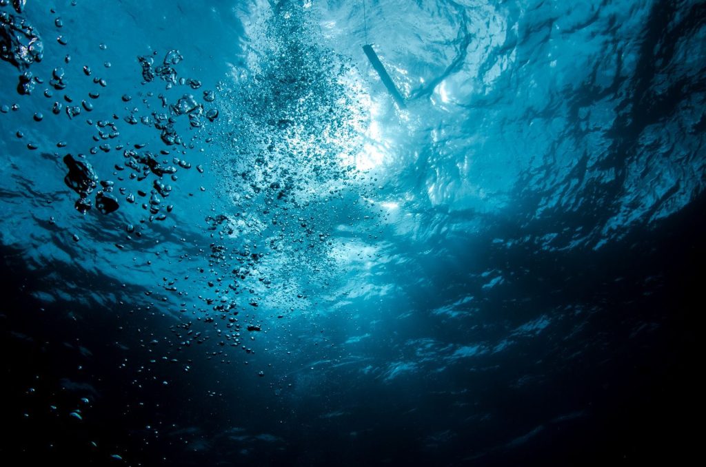 Dynamic underwater photo capturing the serene beauty of blue ocean waters.
