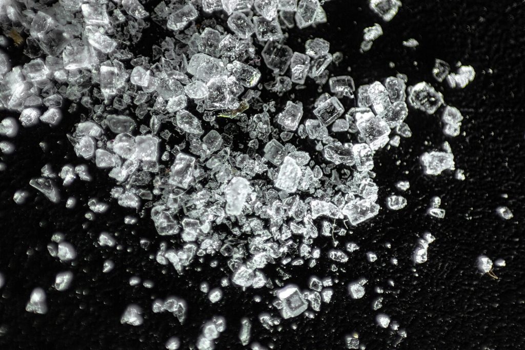 Macro shot showcasing crystal ice cubes against a dark textured background.
