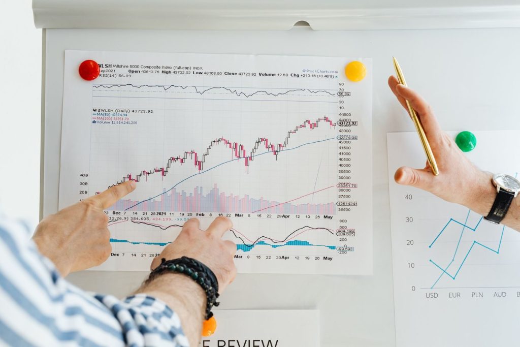 Two professionals analyze stock market graphs with a focus on finance and data trends.