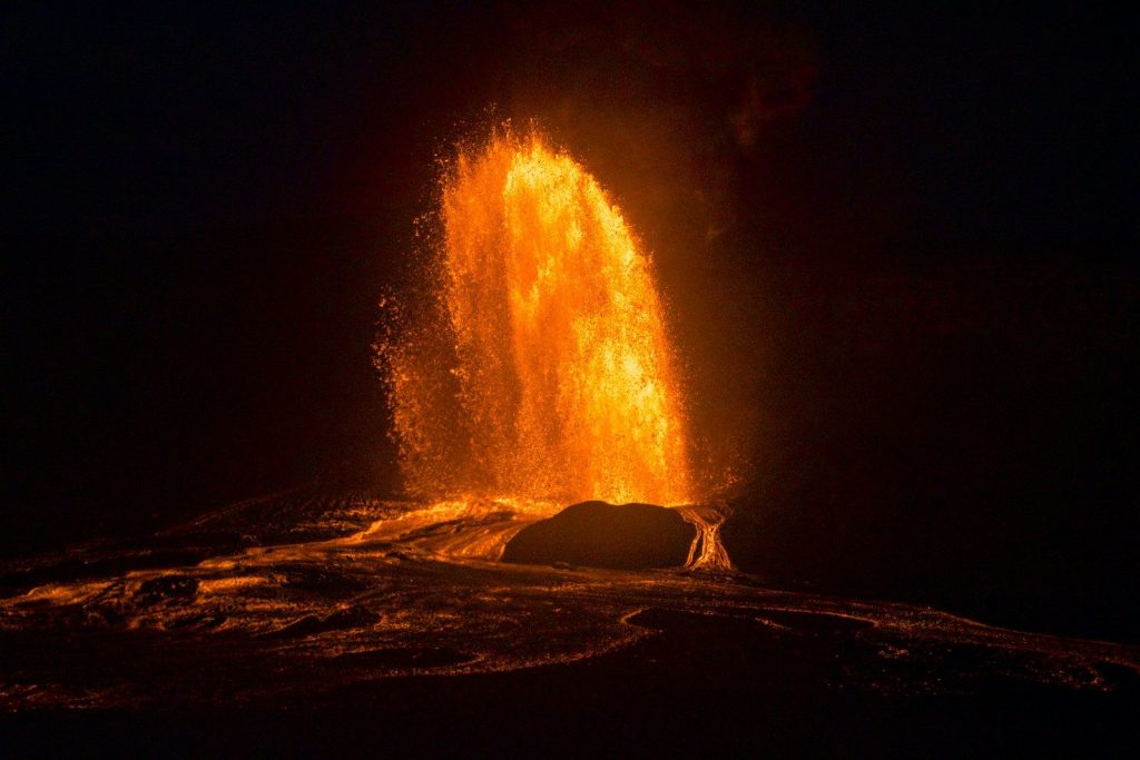 Fiery lava erupting from a volcano at night