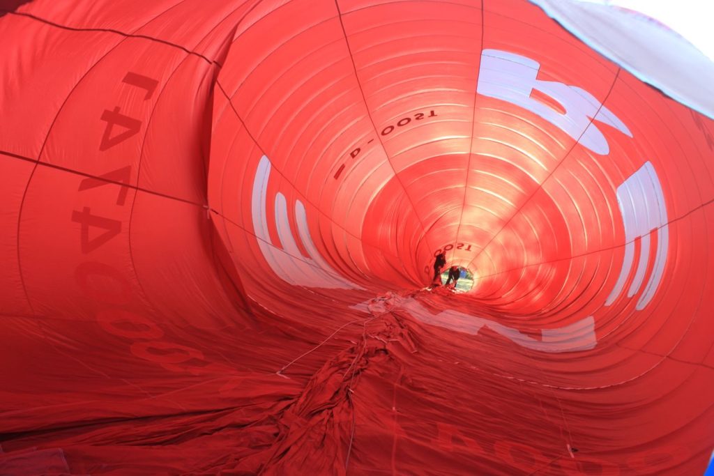 Captivating view inside a vibrant red hot air balloon during preparation for flight.