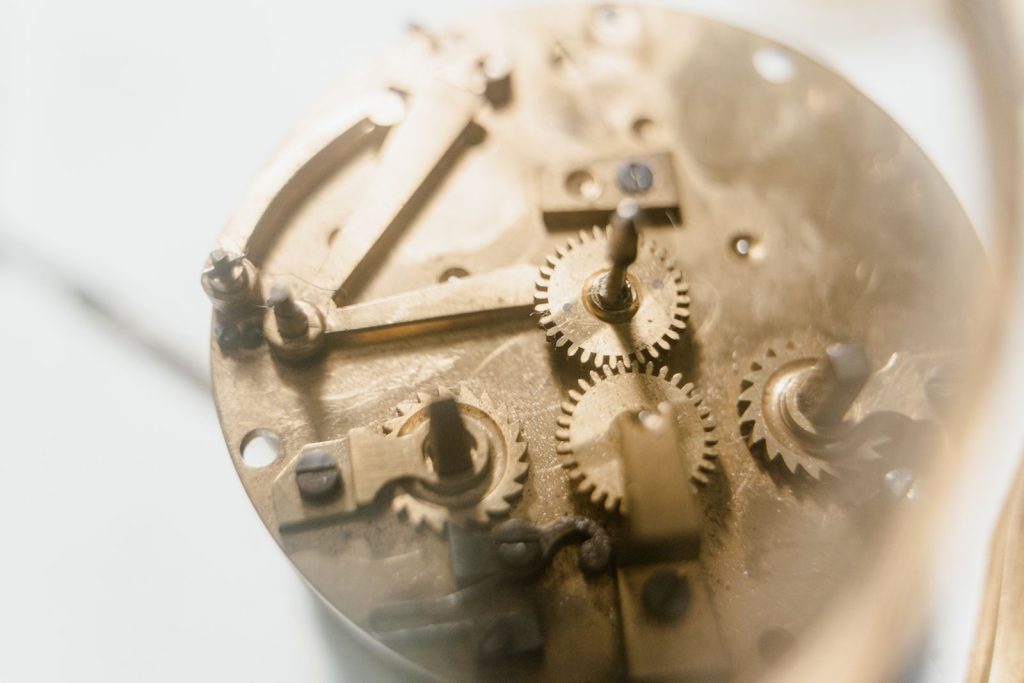 Detailed view of clockwork mechanism showing brass gears and components in soft focus.