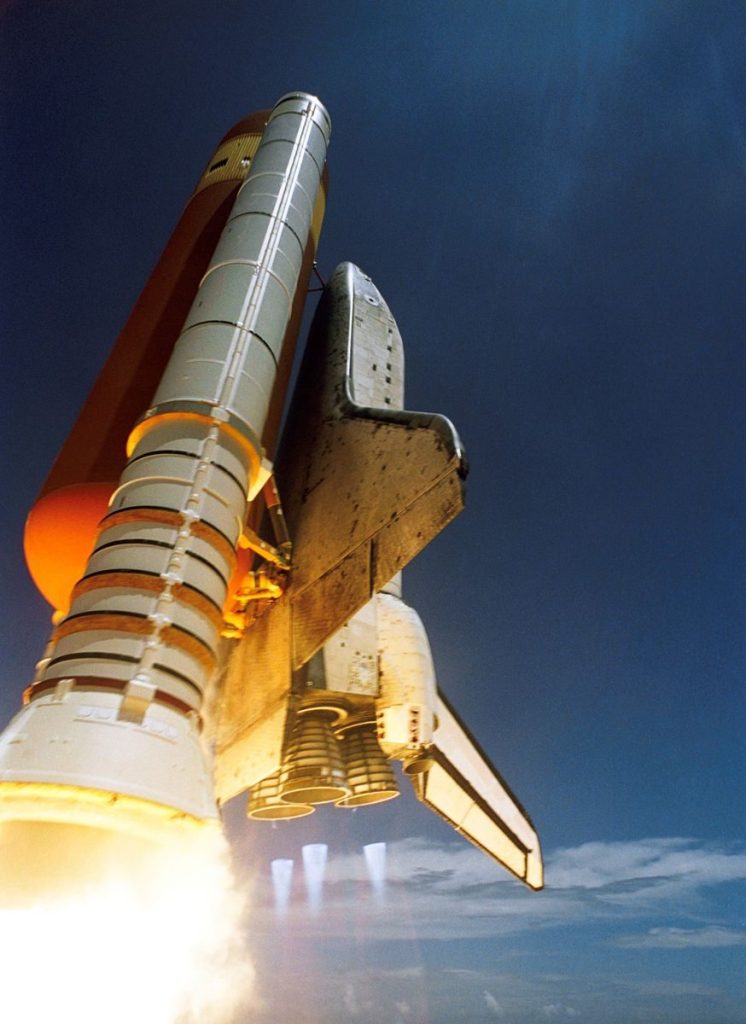 Dynamic low angle view of a space shuttle launch highlighting rocket boosters igniting for space travel.