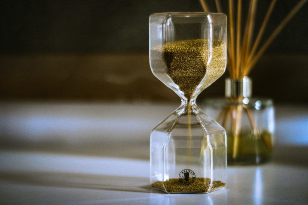 clear hour glass with yellow liquid