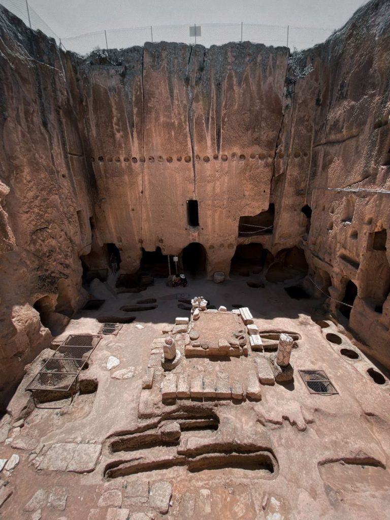 Explore the majestic ruins of an ancient underground cave dwelling with intricate rock formations.