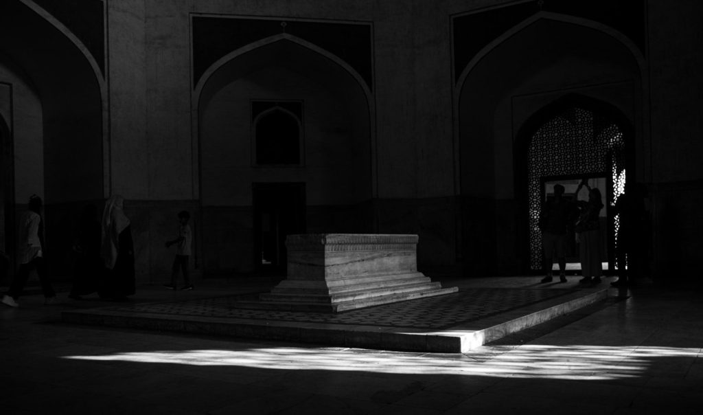 Monochromatic interior with tomb and light patterns.