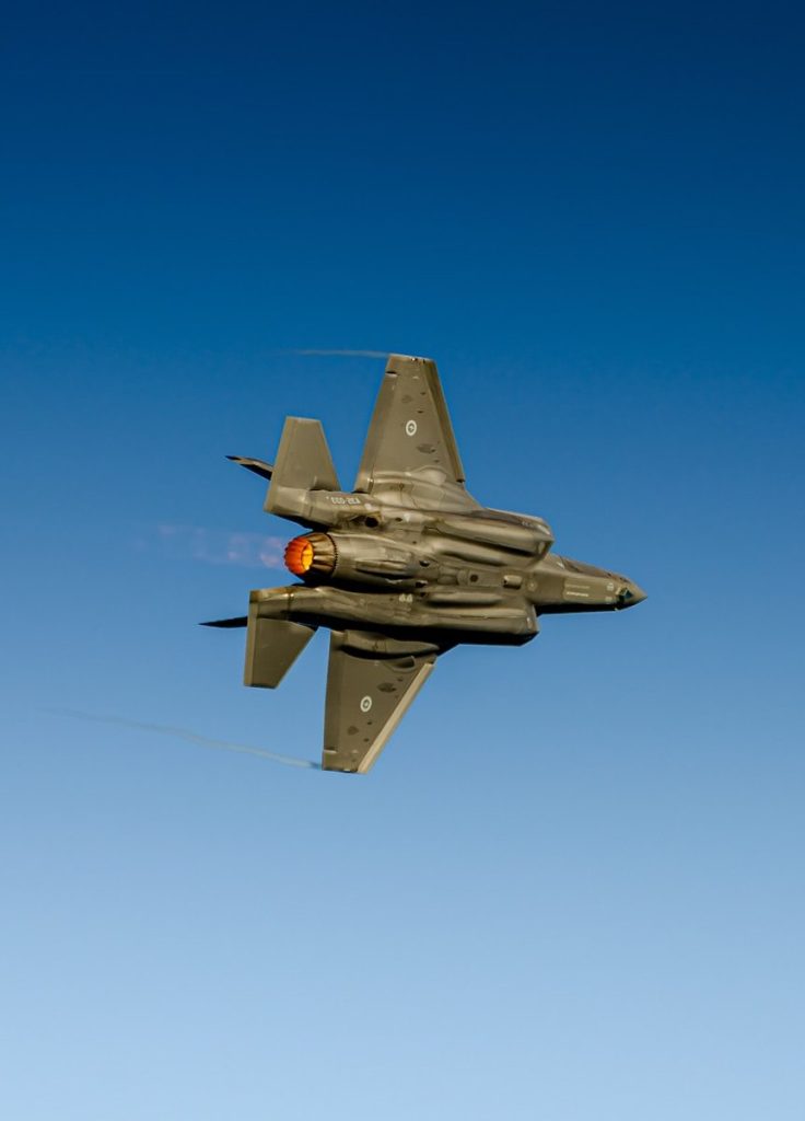 A fighter jet flying through a blue sky