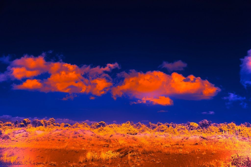 Orange clouds float above an orange landscape.