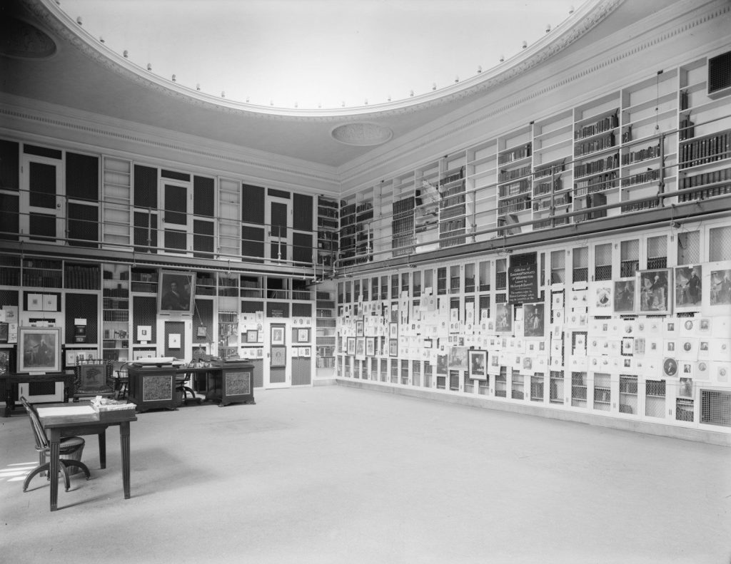 A room filled with framed items and bookshelves.
