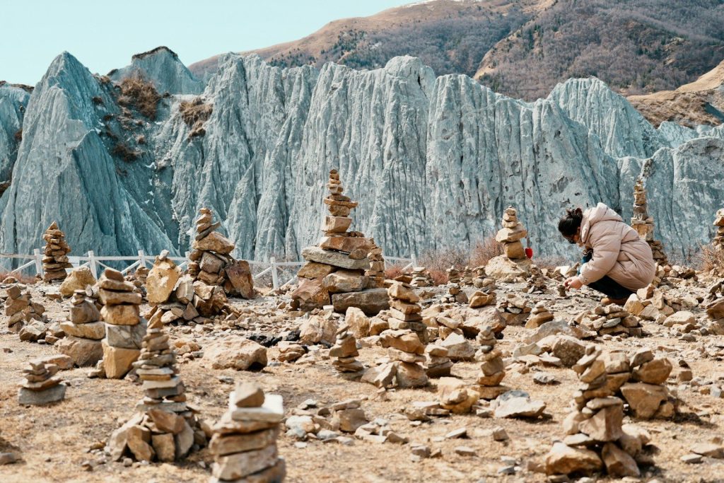 Person arranging stones in a rocky landscape