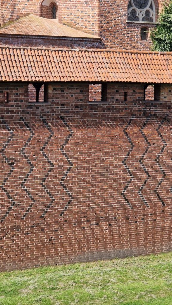 a brick wall with a clock on the top of it