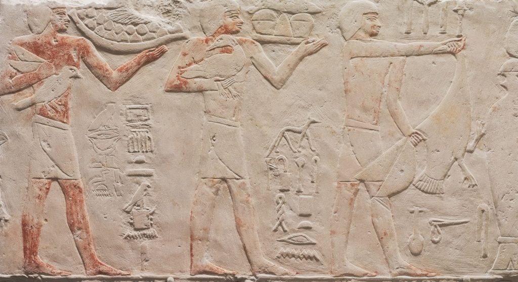 Ancient egyptian relief carving of men with bows and arrows.