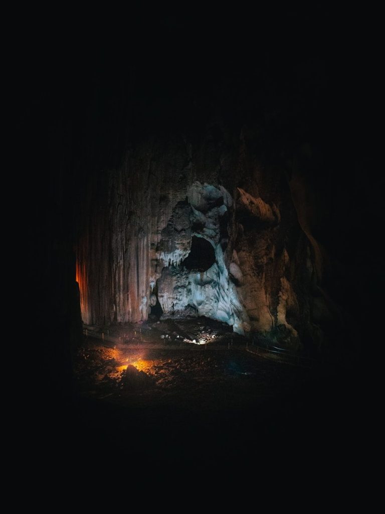 a dark cave with a small fire in the middle of it