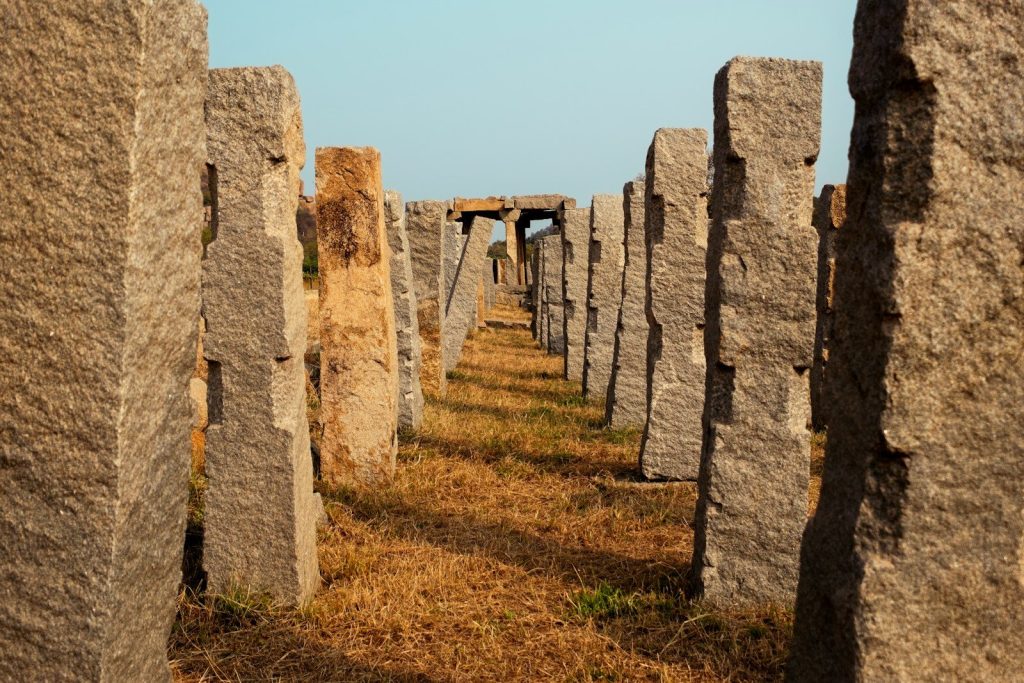 A row of stonehenge standing in the middle of a field
