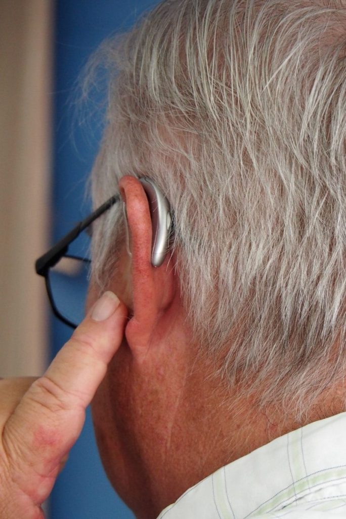 an older man wearing a pair of ear buds