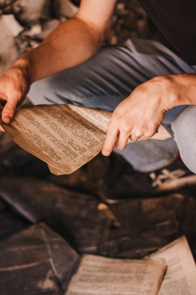 person in gray shirt holding brown book