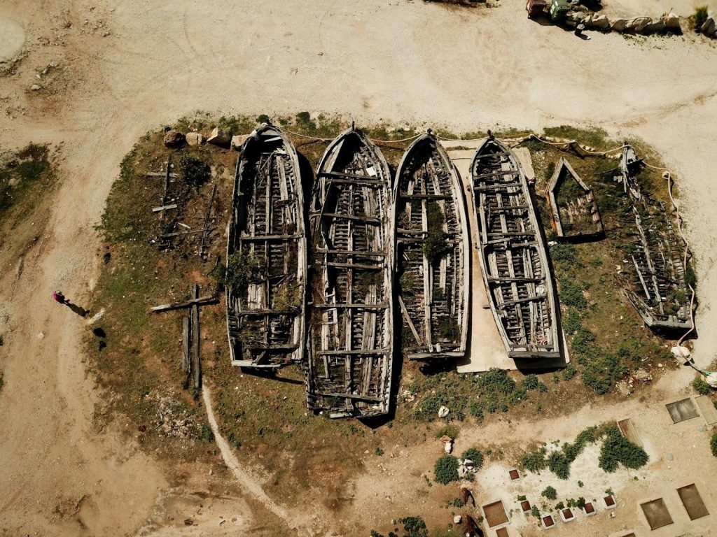 a group of boats sitting on top of a sandy beach