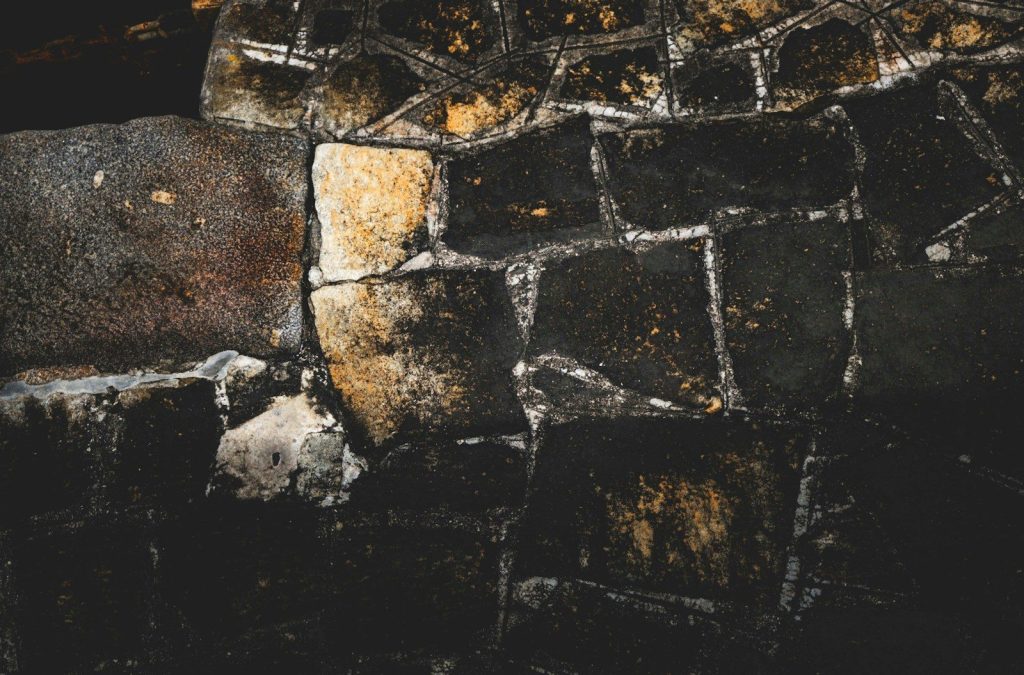 A close-up shows a weathered stone wall.