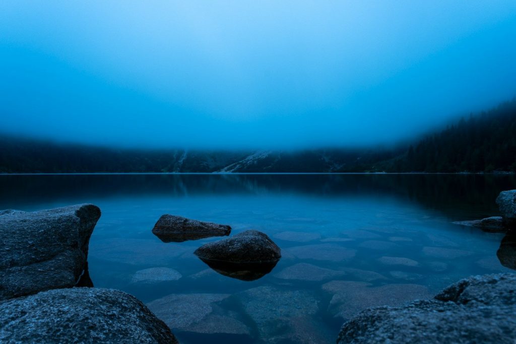 brown rock formation on body of water during daytime