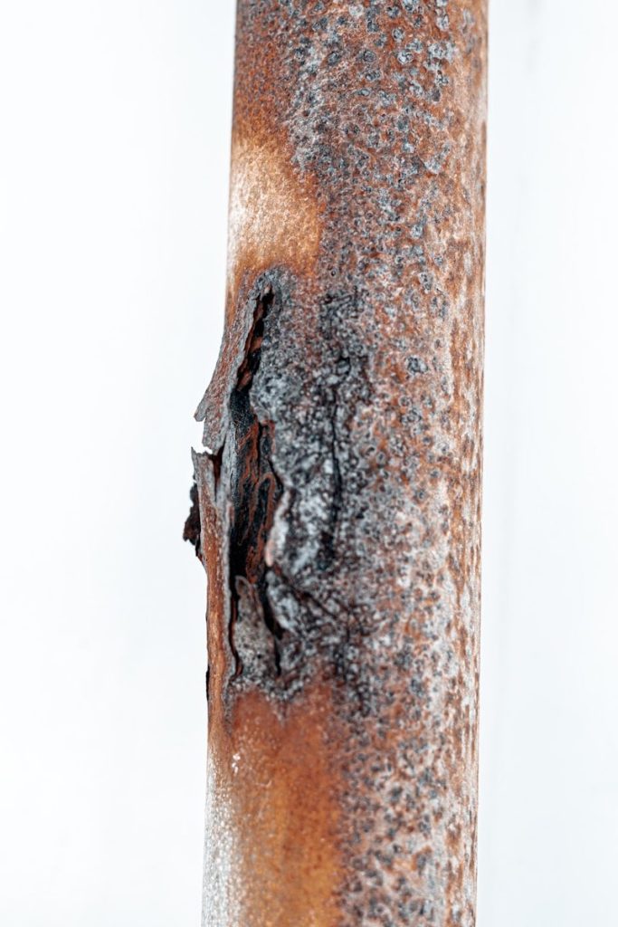 a close up of a rusted metal pole