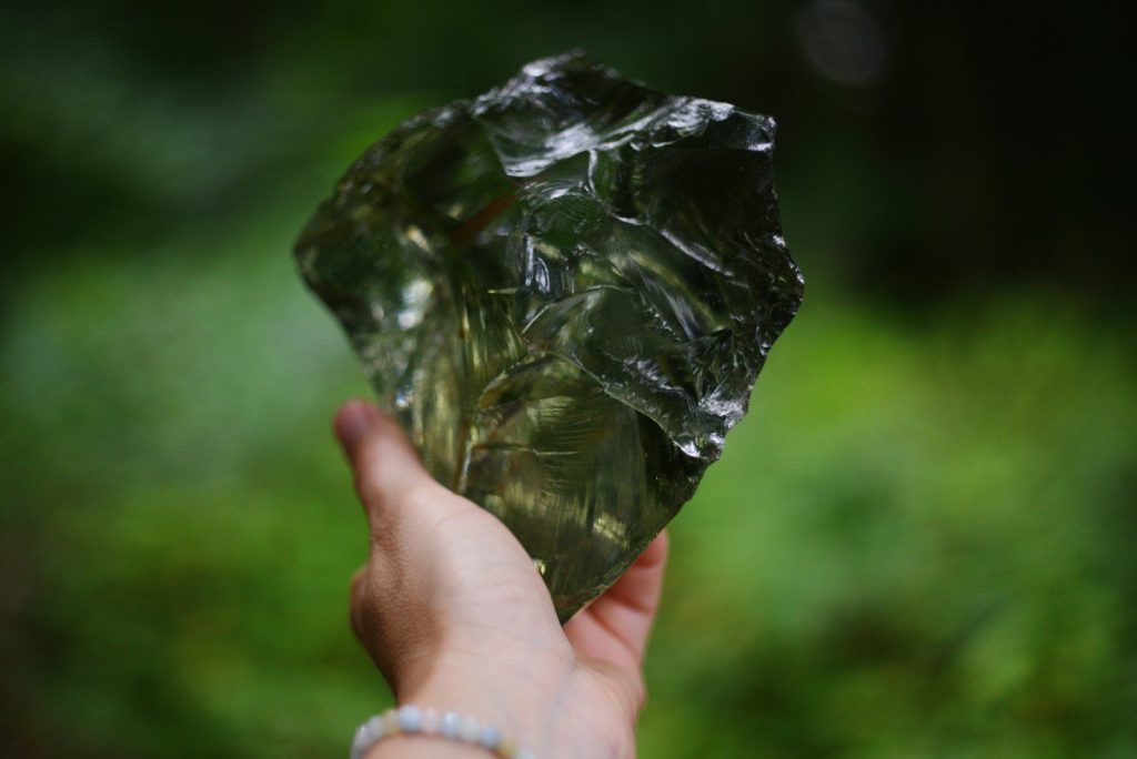 Hand holding a piece of obsidian.