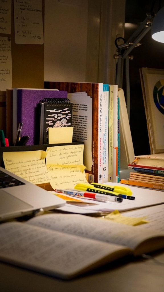 Desk with open book, laptop, and study materials.