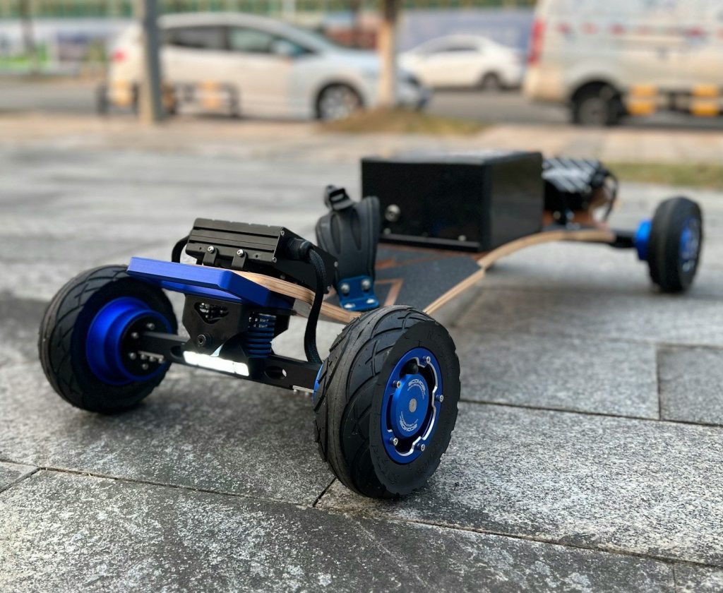 Electric skateboard with large wheels on pavement