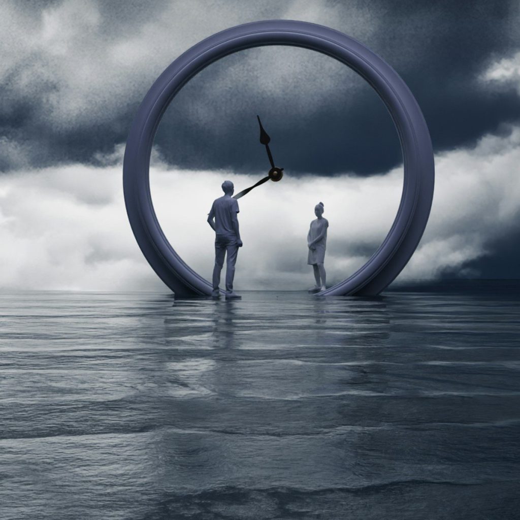 People stand inside a clock on the water.