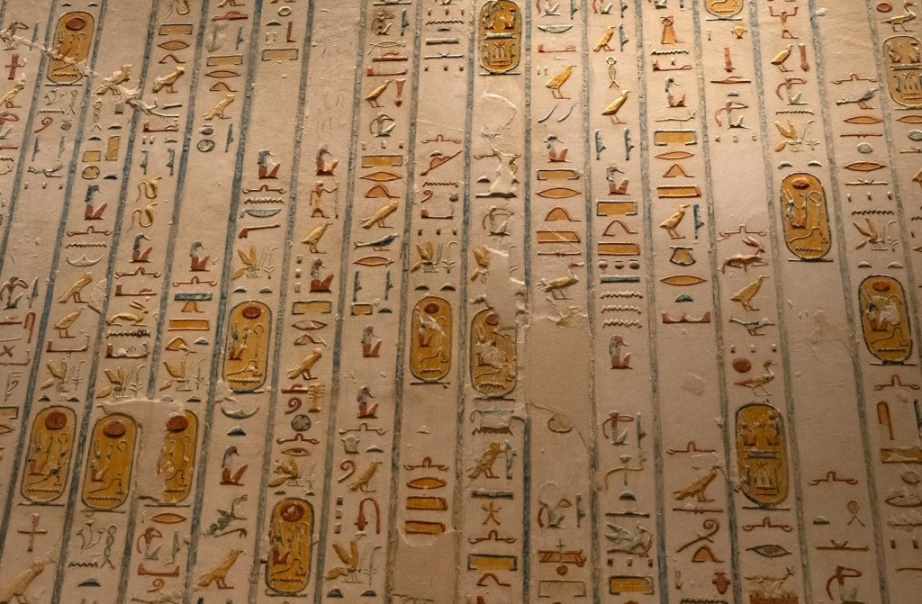 Ancient egyptian hieroglyphs cover a tomb wall.