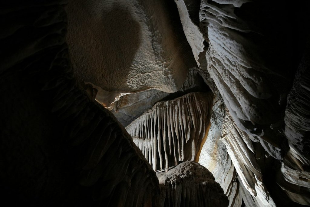 Stalactites hanging from a dark cave ceiling