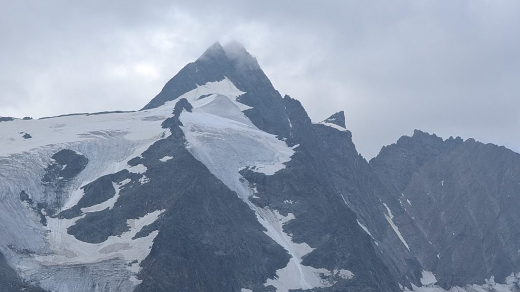 Jagged snowy mountain peak under cloudy sky