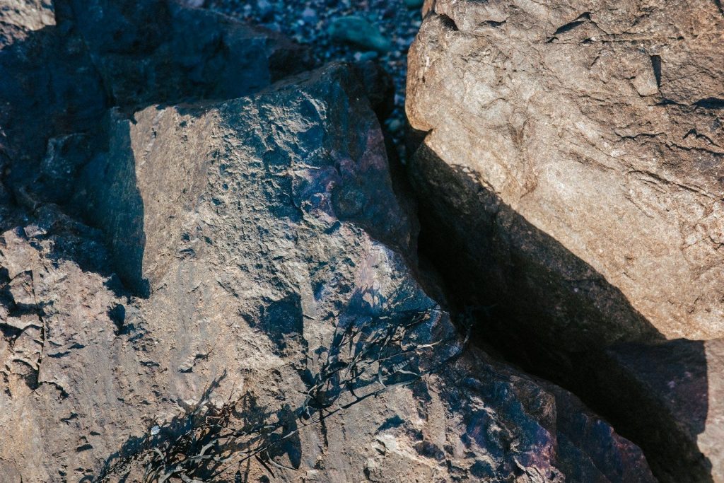 Rough, textured rock formations with contrasting light and shadow.