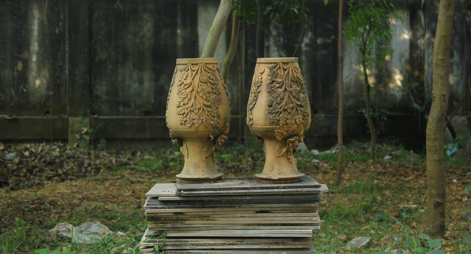 a couple of vases sitting on top of a stack of books