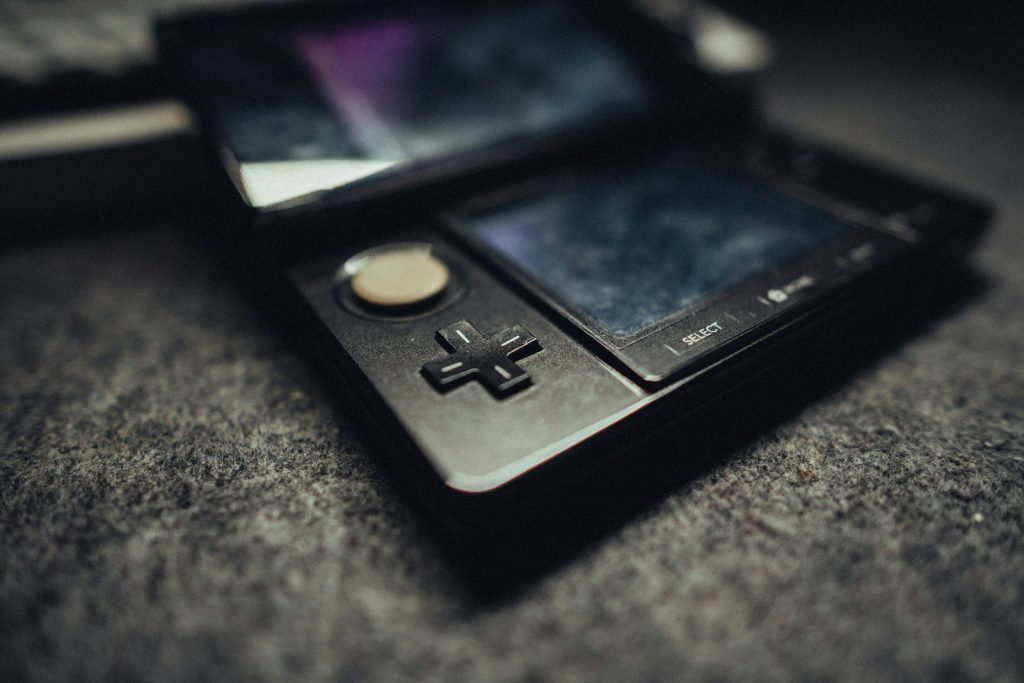 A black handheld gaming device on a textured surface