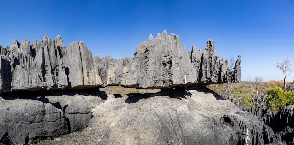 Sharp, jagged grey rock formations under a clear blue sky.