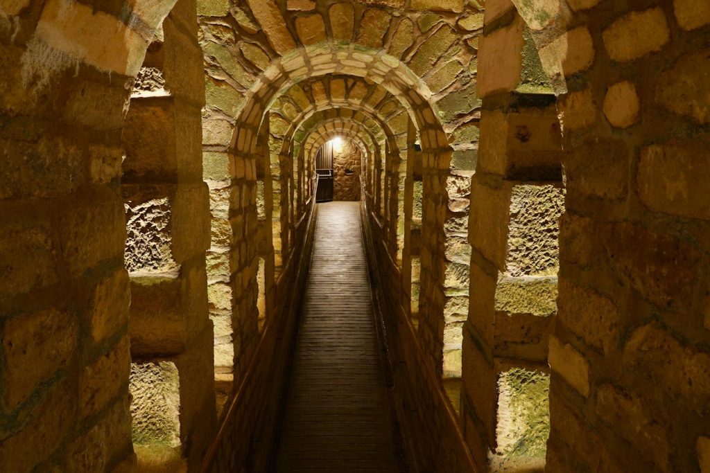 Stone archway tunnel leads into the distance.