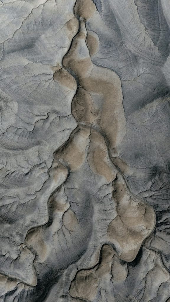 Aerial view of eroded desert landscape with dry riverbeds