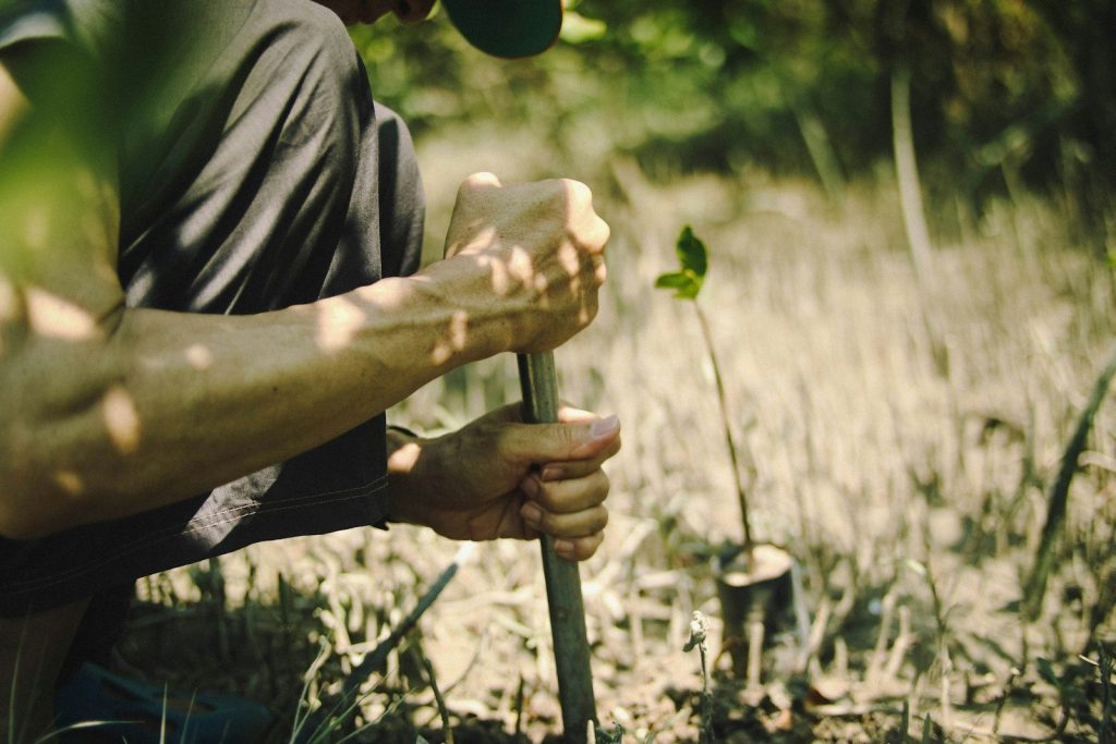 man in black shirt holding green metal pipe