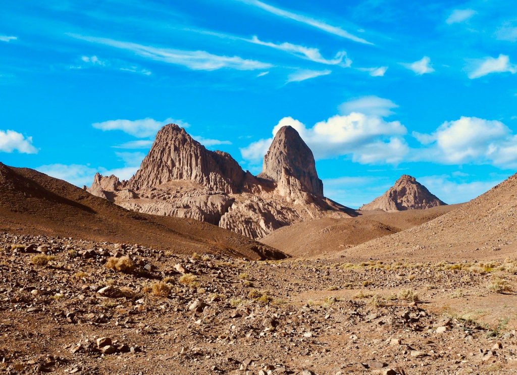 a mountain range in the desert under a blue sky