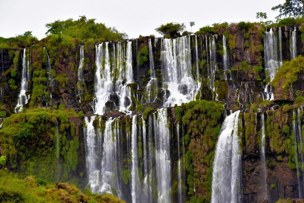 a group of people standing in front of a waterfall