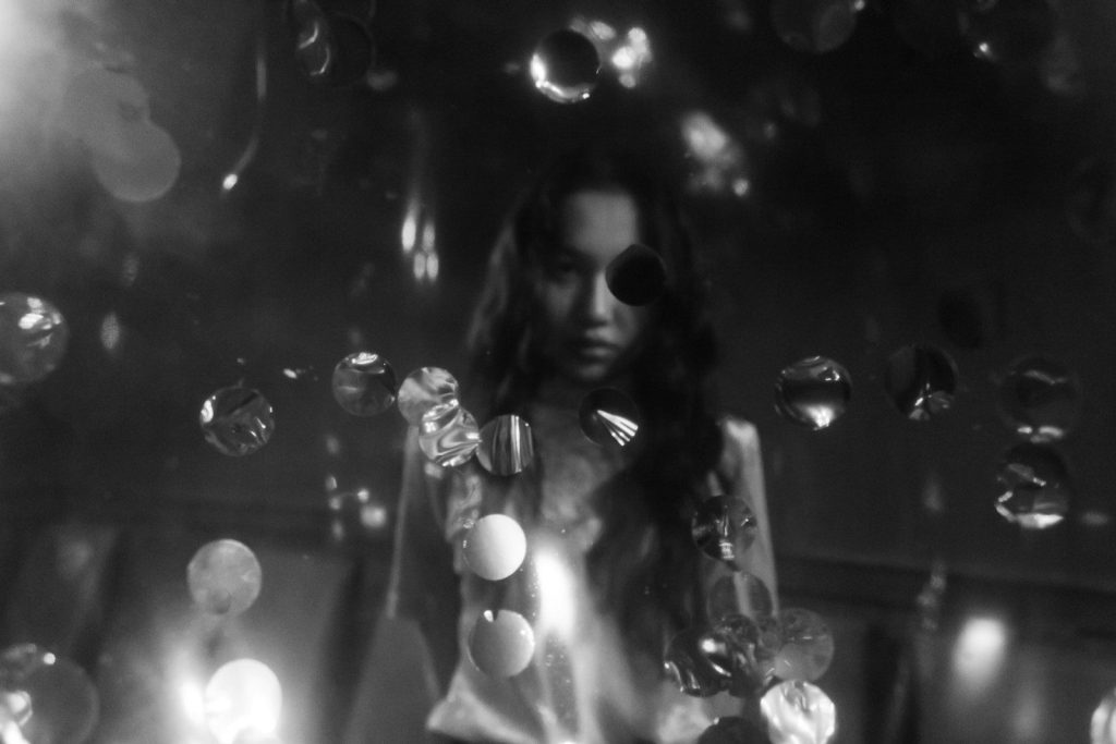 a woman standing in front of a bunch of bubbles