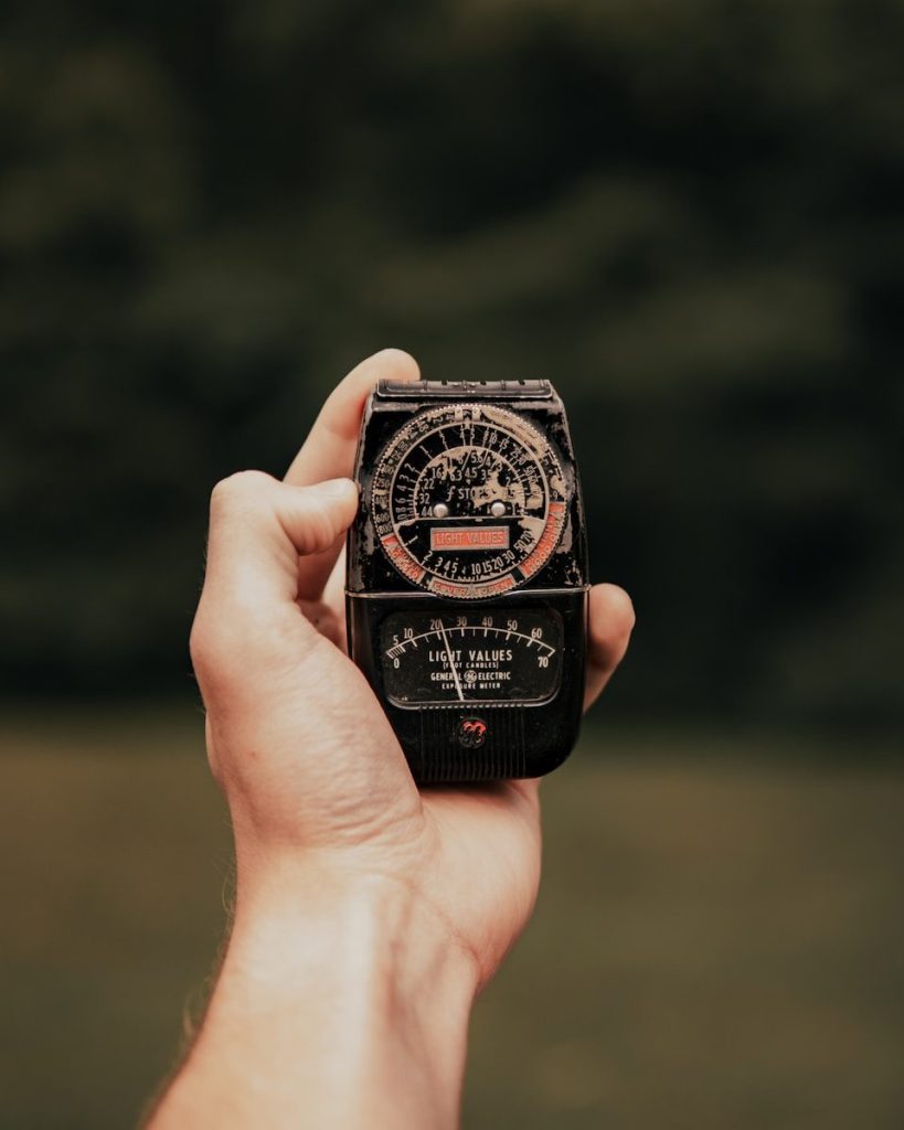a hand holding a small black and red object